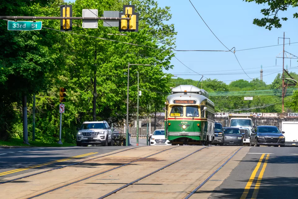 Vintage green Phialdelphia trolley moving down street